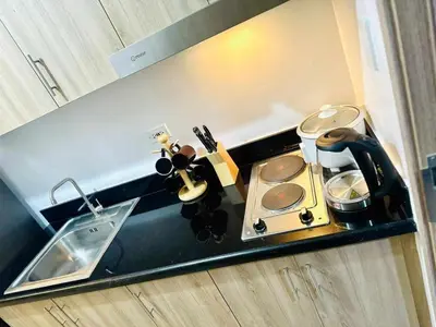 a kitchen counter top with a sink and a stove at Cozy Retreat at Shore2 Residences in Manila
