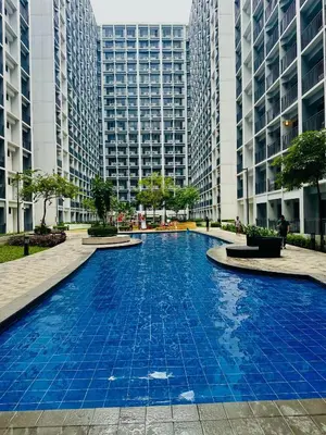 a blue pool in a city with tall buildings at Cozy Retreat at Shore2 Residences in Manila