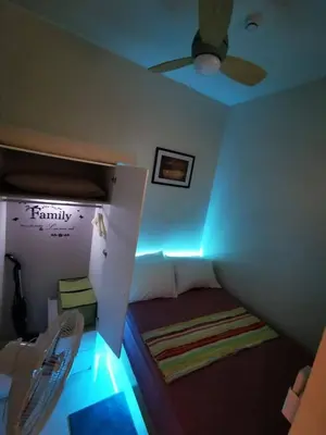 a room with a bed with a ceiling fan and lights at Aldo shore 3 tower 2 mall of Asia in Manila
