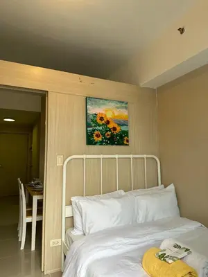 a bedroom with a bed with a painting above it at Modern & Cozy Two BR in Jazz Residences Makati City in Manila