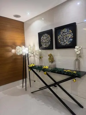 a room with a table with flowers on a wall at JUVREY 1 BR Studio Unit with balcony in Manila