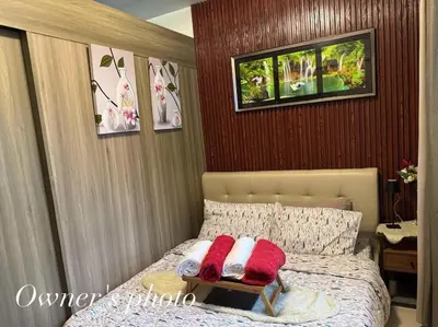 a bedroom with a bed with two pillows on it at JUVREY 1 BR Studio Unit with balcony in Manila