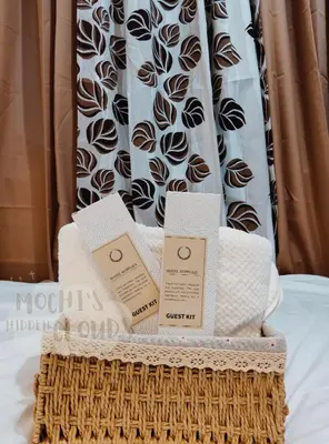 a basket filled with towels and boxes on a bed at Condotel with Balcony Near Airport and MOA with Games & Karaoke in Manila