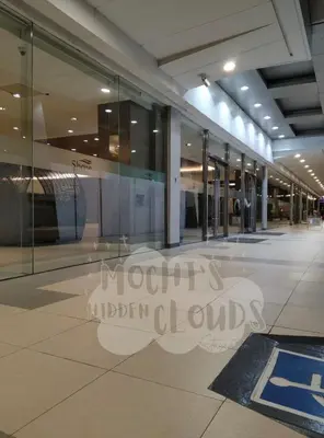 a large building with glass windows in a mall at Condotel with Balcony Near Airport and MOA with Games & Karaoke in Manila