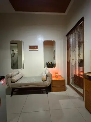 a living room with a couch and a mirror at Quaint Roces Studio in Manila