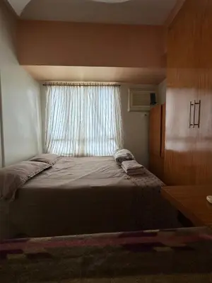 a small bedroom with a bed and a window at Quaint Roces Studio in Manila