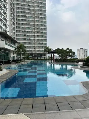 a large swimming pool in front of a tall building at Quaint Roces Studio in Manila