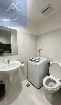 a white bathroom with a toilet and a sink at 1bedroom with balcony at Sea Residences near MOA and SMX in Manila