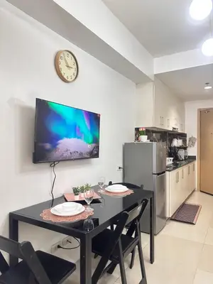 a dining room with a table and a clock on a wall at 1bedroom with balcony at Sea Residences near MOA and SMX in Manila