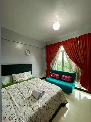 a bedroom with a large bed and a blue couch at Tropical unit in Manila