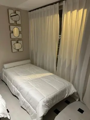 a white bed in a room with a window at Spacious 2BR Apartment Hotel near City of Dreams, Airport, MOA, Okada, Ayala Malls, and Solaire Casino with free 5 pool access in Manila