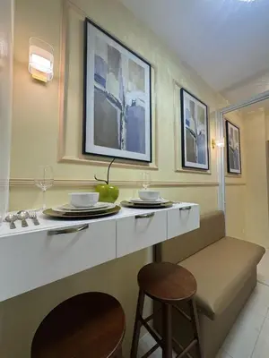 a kitchen with a counter with two stools and a table at The Horizon Suite by Crib2GO in Manila