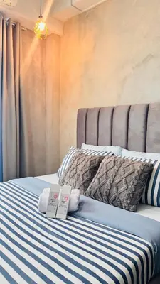 a bed with two towels and two books on it at GreySky Studio in Manila