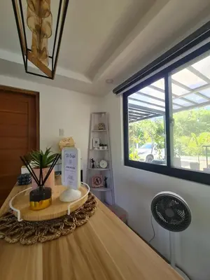 a room with a table with a fan and a window at The Zentuary - House with pool in Amadeo