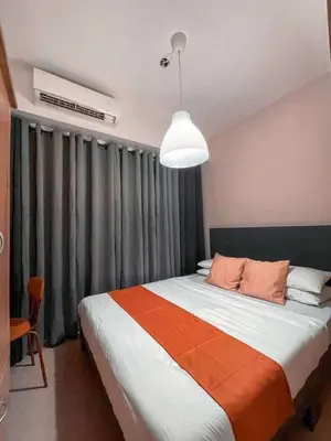a bedroom with a large bed and a large window at Wowstaycation in Manila