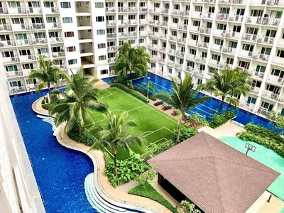 an aerial view of a resort with a pool and palm trees at Wowstaycation in Manila