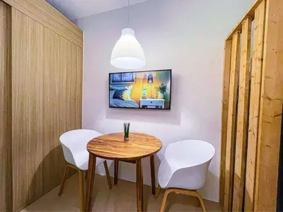 a dining room with a table and two white chairs at Wowstaycation in Manila