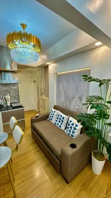 a living room with a couch and a chandelier at Azure Urban Resort Residences, 1BR Santorini 18th floor in Manila