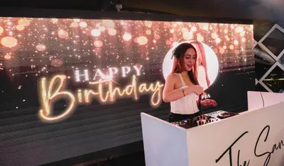 a woman standing in a box with a happy birthday sign at Azure Urban Resort Residences, 1BR Santorini 18th floor in Manila
