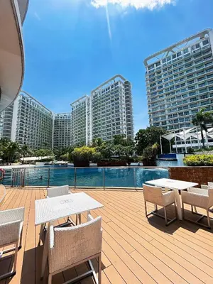 a patio with tables and chairs with buildings in the background at Azure Urban Resort Residences, 1BR Santorini 18th floor in Manila