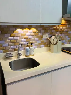 a kitchen sink with two bottles on a counter at Azure Parañaque, 1BR Bahamas 15th floor in Manila