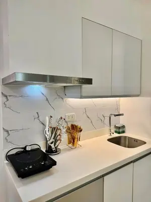 a white kitchen with a sink and a counter top at Azure Parañaque, 1BR Bahamas 19th floor in Manila