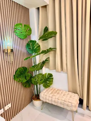 a plant in a room with a bench and curtains at Azure Parañaque, 1BR Bahamas 19th floor in Manila
