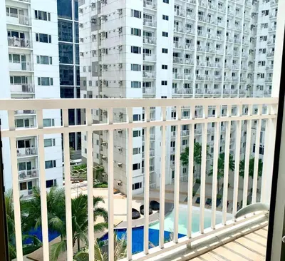 a balcony with a view of a large building at Wowstaycation in Manila