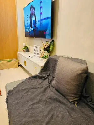 a bedroom with a bed and a flat screen tv at Cozy Studio in Viceroy Near Venice Mall in Manila