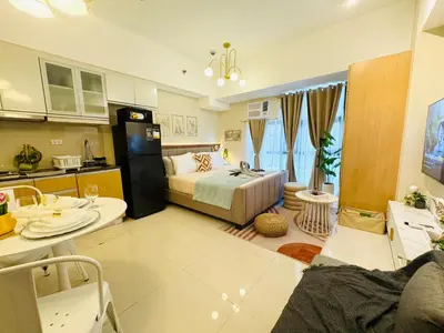 a large room with a bed and a kitchen at Cozy Studio in Viceroy Near Venice Mall in Manila