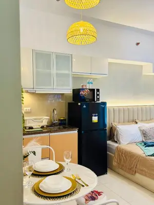 a small kitchen with a table with plates on it at Staycation in viceroy mckinley near venice grand canal in Manila