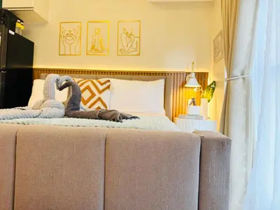 a bedroom with a bed with two stuffed animals on it at Staycation in viceroy mckinley near venice grand canal in Manila
