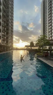 a man swimming in a swimming pool with buildings at Radiance manila bay in Manila
