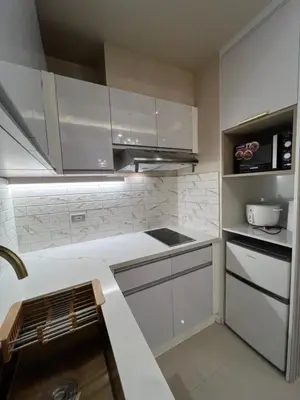 a kitchen with white cabinets and a sink at Radiance manila bay in Manila