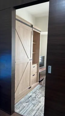 a sliding wooden door in a room with a desk at 1 Bedroom Cozy and Relaxing Place in Manila