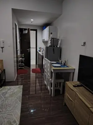 a living room with a kitchen with a counter and a table at 1 Bedroom Cozy and Relaxing Place in Manila