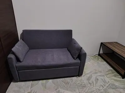 a couch sitting in a living room next to a table at 1 Bedroom Cozy and Relaxing Place in Manila