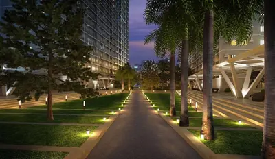 a walkway in a park with palm trees and lights at 1 Bedroom unit in Fame Residence in Manila