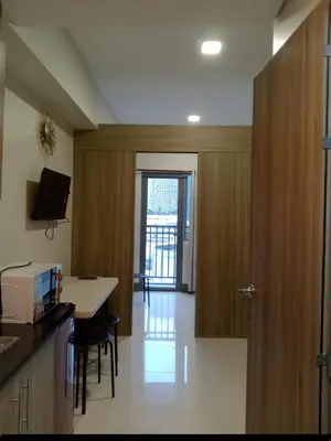 a kitchen and dining room with a table and a door at 1 Bedroom unit in Fame Residence in Manila