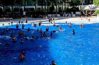 a group of people in a pool of blue water at Azure Urban Resort Staycation 2 bedrooms beach view, 9th floor in Manila