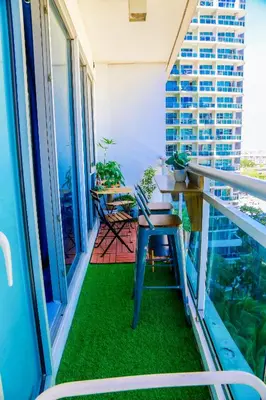 a balcony with a table and chairs on it at Azure Urban Resort Staycation 2 bedrooms beach view, 9th floor in Manila