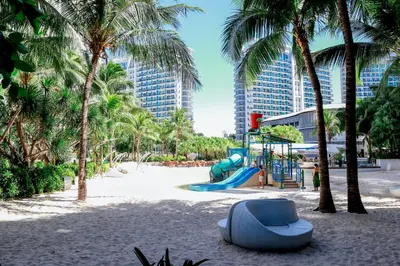 a playground on the beach with palm trees at Azure Urban Resort Staycation 2 bedrooms beach view, 9th floor in Manila