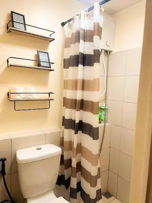 a bathroom with a toilet and a shower curtain at Jungle Hostel 1062 in Manila