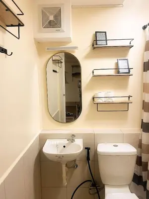 a bathroom with a sink and a mirror and a toilet at Jungle Hostel 1062 in Manila