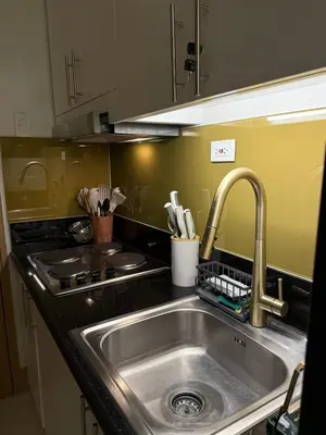 a kitchen with a stainless steel sink and a stove at Glamorous SMDC Shore 3, 5 Star Rate BnB-Wifi-Netflix in Manila
