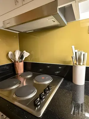 a stove top in a kitchen with some utensils at Glamorous SMDC Shore 3, 5 Star Rate BnB-Wifi-Netflix in Manila