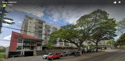 a street with cars parked in front of a building at Cozy Suite with Private Patio near Nuvali in Silang