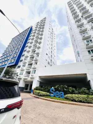 a large white building with a sea sign in front of it at Sea Residence MOA - Paul Condotel in Manila