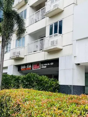 a white building with balconies and a palm tree at Sea Residence MOA - Paul Condotel in Manila