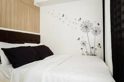 a bedroom with a white bed with dandelions on the wall at Family Suite near MOA in Manila